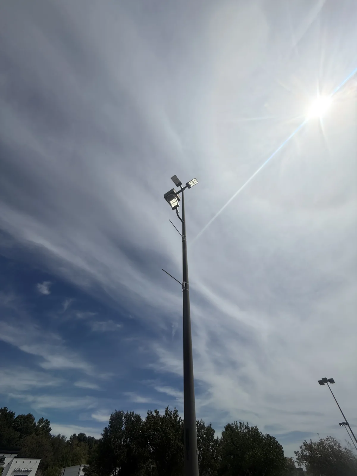 Illuminated area-light fixture mounted on a tall pole
