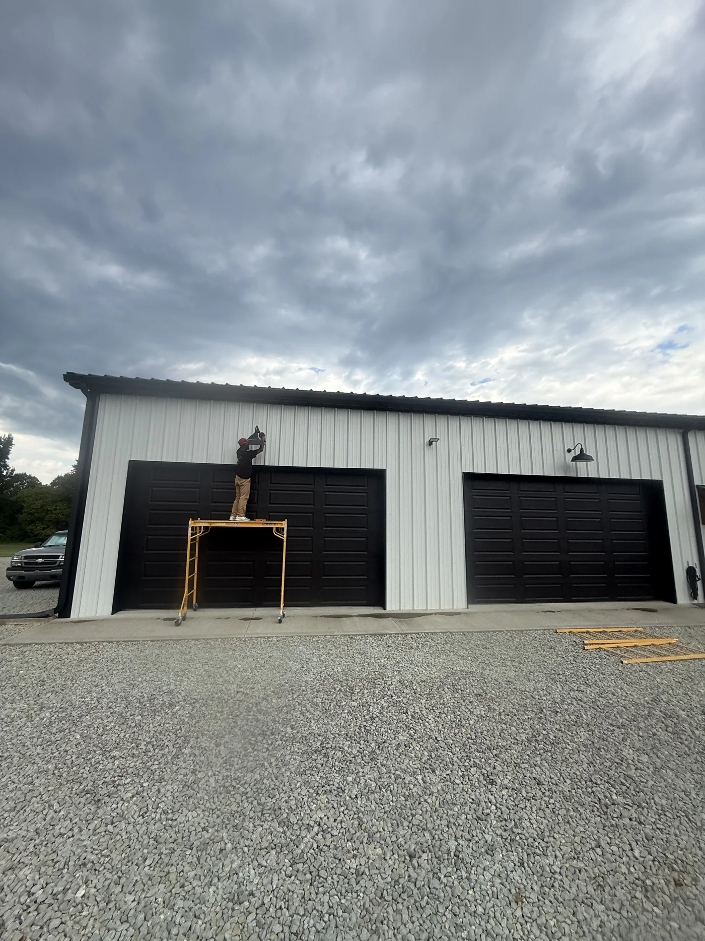 Metal commercial building with two service-bay doors and exterior lights